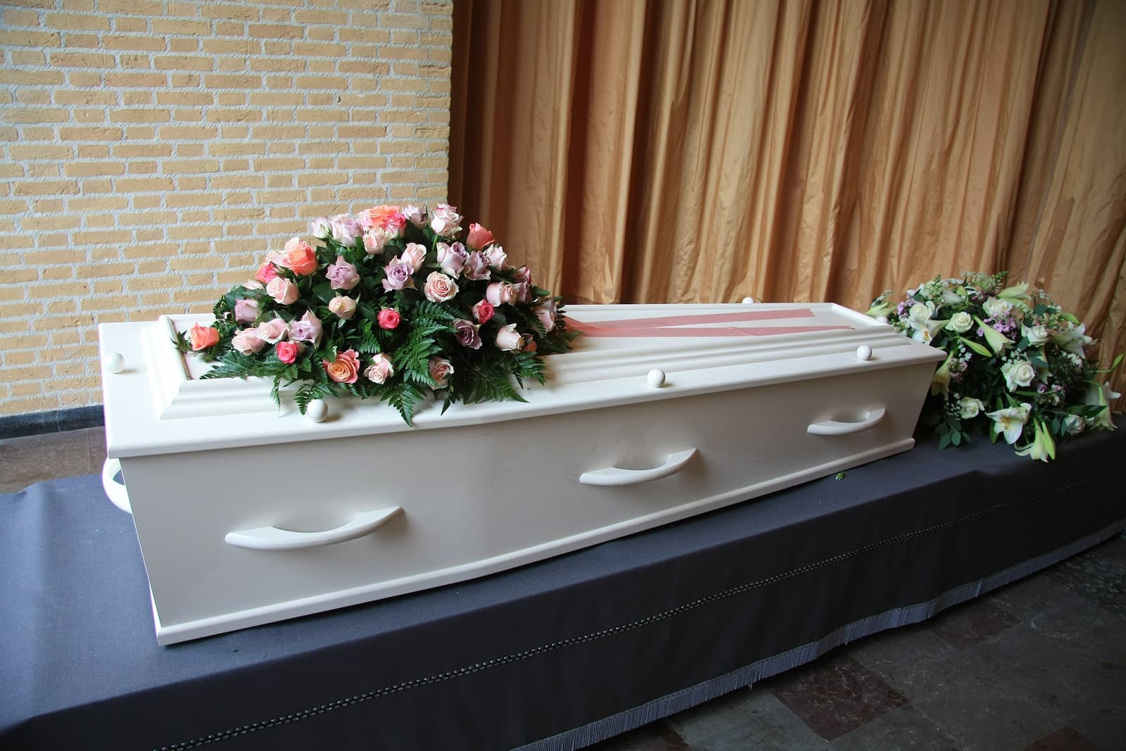 An image of a coffin with memorial flowers