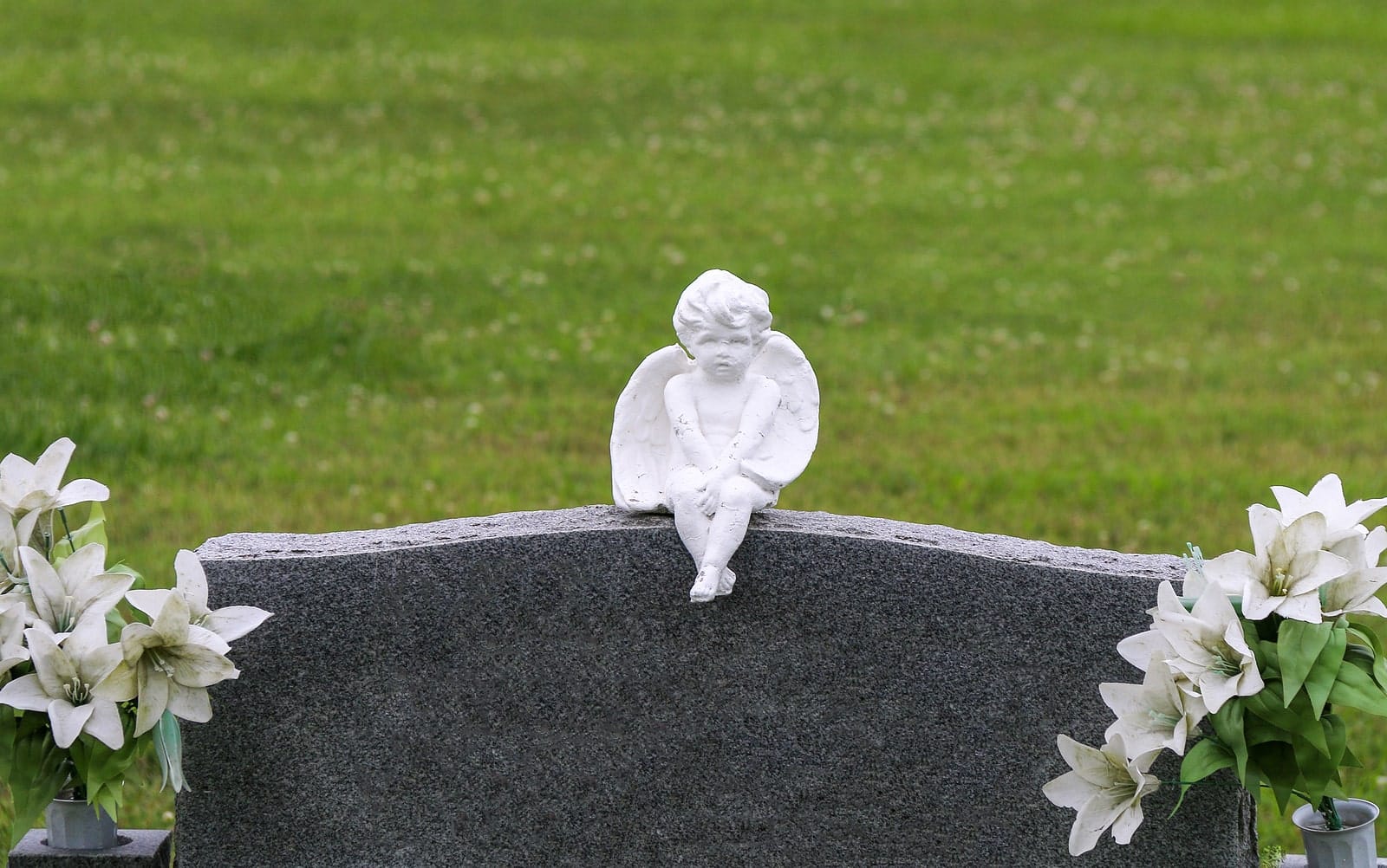 a cherub sculpture on a headstone