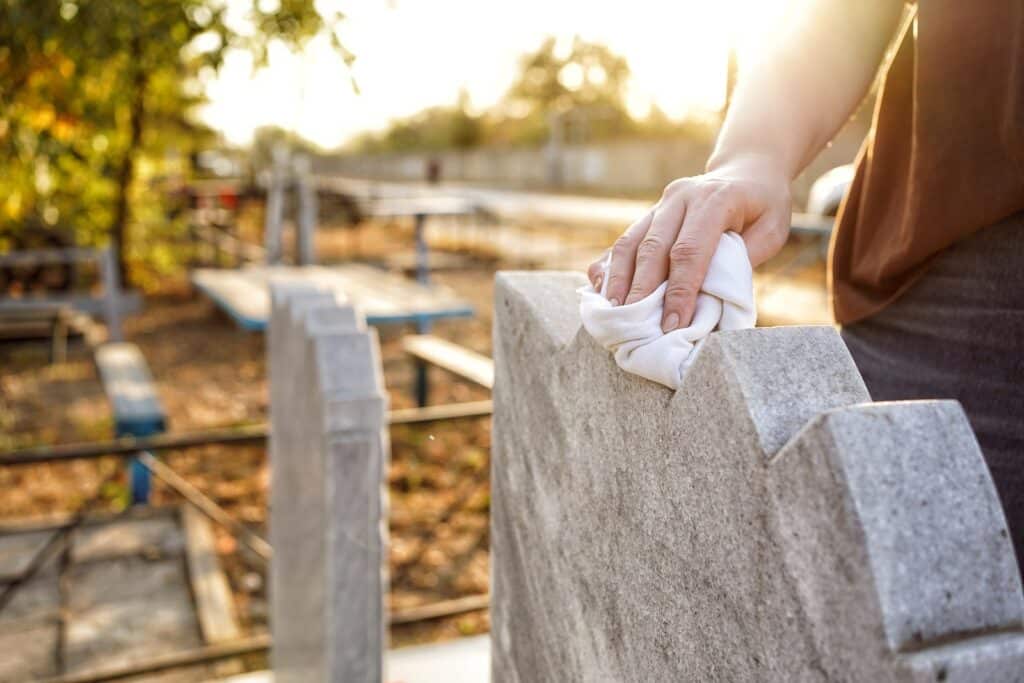 Image of a person cleaning a grave marker on Tegeler Monument Company's website