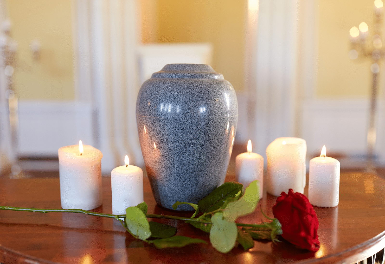 Image of a cremation urn with candles and a rose